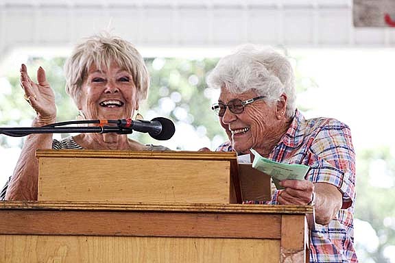 Betty Haffner, right, giggles as Rose Snow tells a story during the Cincinnatus LeagueÕs Jay County Hall of Fame induction ceremony Wednesday in the FarmerÕs Building during the Jay County Fair. Six senior citizens are selected annually by the group for their service to the community. (The Commercial Review/Bailey Cline)