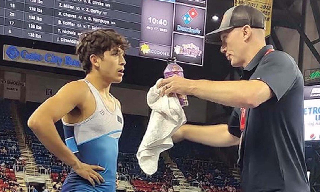 Tony Wood gets coached by Wade McClurg of Warrior RTC during the U.S. Marine Corps Junior National freestyle tournament last week. Wood finished with tied for 13th in the tournament after going 4-2 in his matches between July 17 and 18. (Special to The Commercial Review)