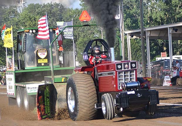 Dave Armstrong of Wilmington, Ohio drives his super stock diesel tractor during the third session of the National Tractor Pullers Association competition at Ambassador Park in Fort Recovery on Saturday evening. (The Commercial Review/Andrew Balko)
