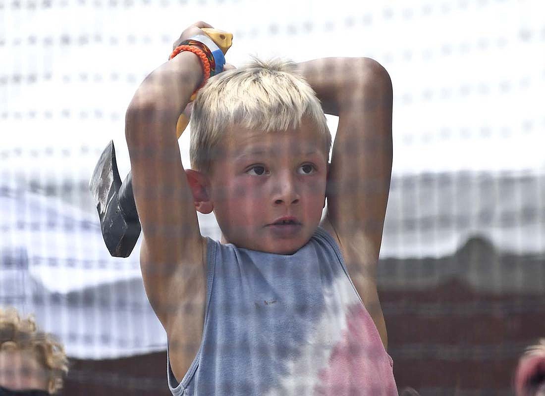 Rebel Fox, an 8-year-old Geneva resident, rears back to toss an axe Saturday during Swiss Days in Berne. Busted Haft Throwing of Bluffton had the attraction set up at the festival. (The Commercial Review/Ray Cooney)