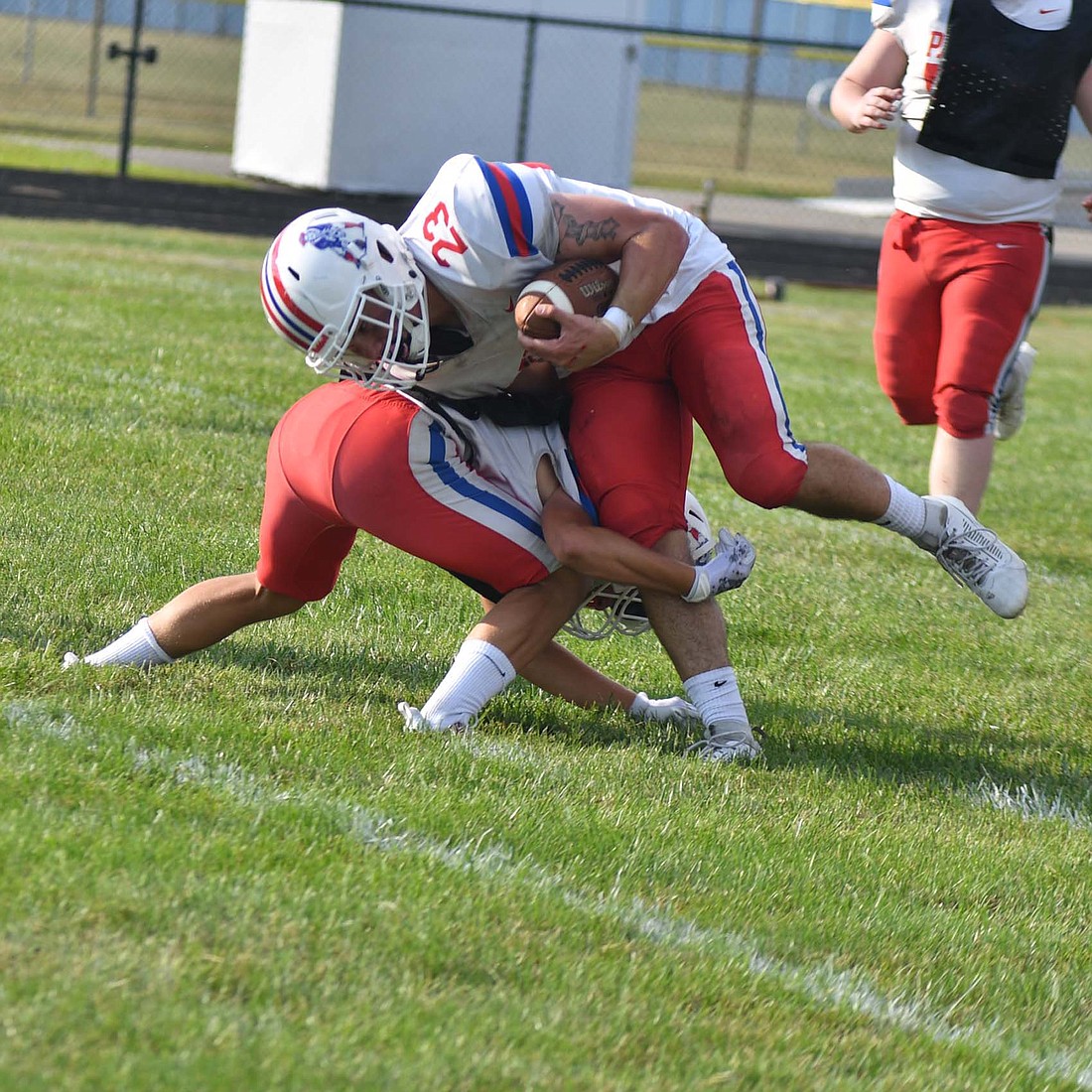 AJ Myers (23) meets Grant Wendel at the one-yard line during the Jay County High School football red-blue scrimmage Friday evening. Myers flipped over Wendel for the score. (The Commercial Review/Andrew Balko)