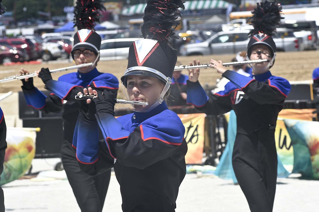 Emma LeMaster of the Jay County High School Marching Patriots plays the piccolo in front of flute players Alexander Smith and Hannah Boggs during FridayÕs preliminaries at the Indiana State Fair. (The Commercial Review/Ray Cooney)