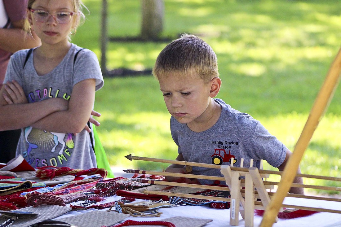 A boy looks at arrows displayed by a member of the Eastern Shawnee tribe during Fort Recovery State Museum's "Beyond the Battlefield: Interpreting St. ClairÕs Defeat through the Eyes of Tribal Citizens" event Saturday. Members of the Shawnee, Miami and Wyandotte tribes set up stations in the museum and surrounding area to share their tribe's culture and history relating to the 1791 battle in Fort Recovery. (The Commercial Review/Bailey Cline)