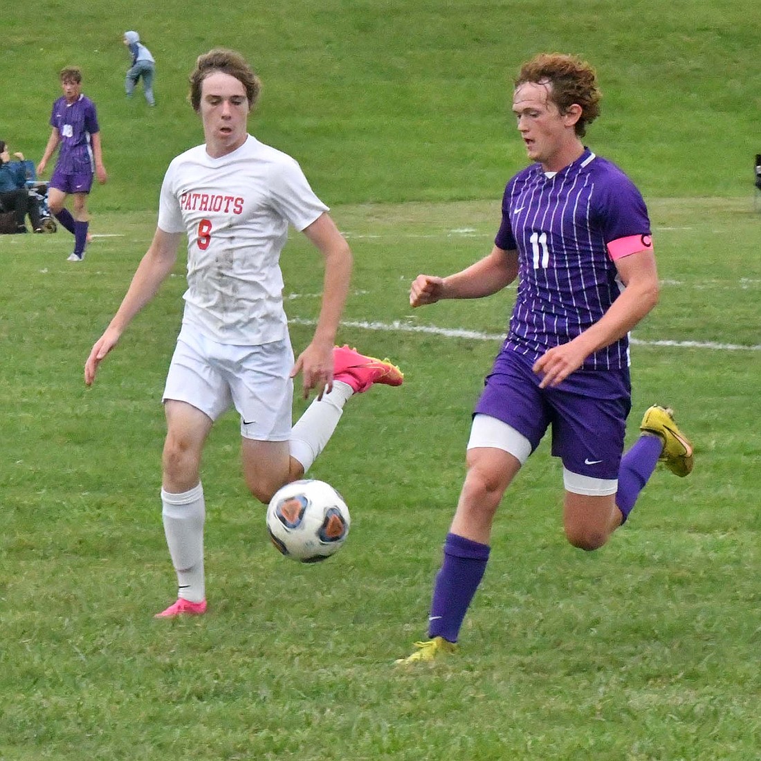 JCHS and Muncie Central seniors Brayden Collins and Finn Gruver run down a ball during Tueday’s season opener. The Patriots fell to the Bearcats 5-2 in the contest. Gruver netted two goals while Collins scored one on a penalty kick. (The Commercial Review/Andrew Balko)