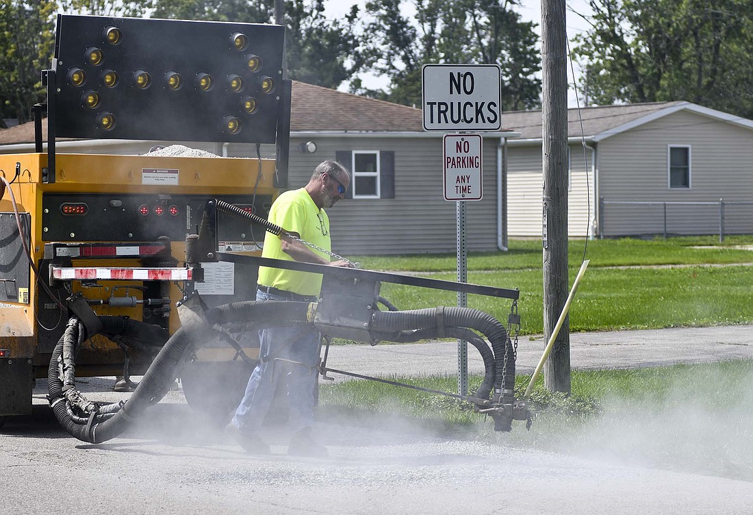 Dust flies Thursday morning as Todd Nichols of Portland Street Department uses stone to fill in a spot on Morton Street just south of Votaw Street. Street department workers were patching Morton, Votaw and other streets in the area Thursday morning ahead of next week’s Tri-State Antique Engine and Tractor Show, which begins Wednesday. (The Commercial Review/Ray Cooney)