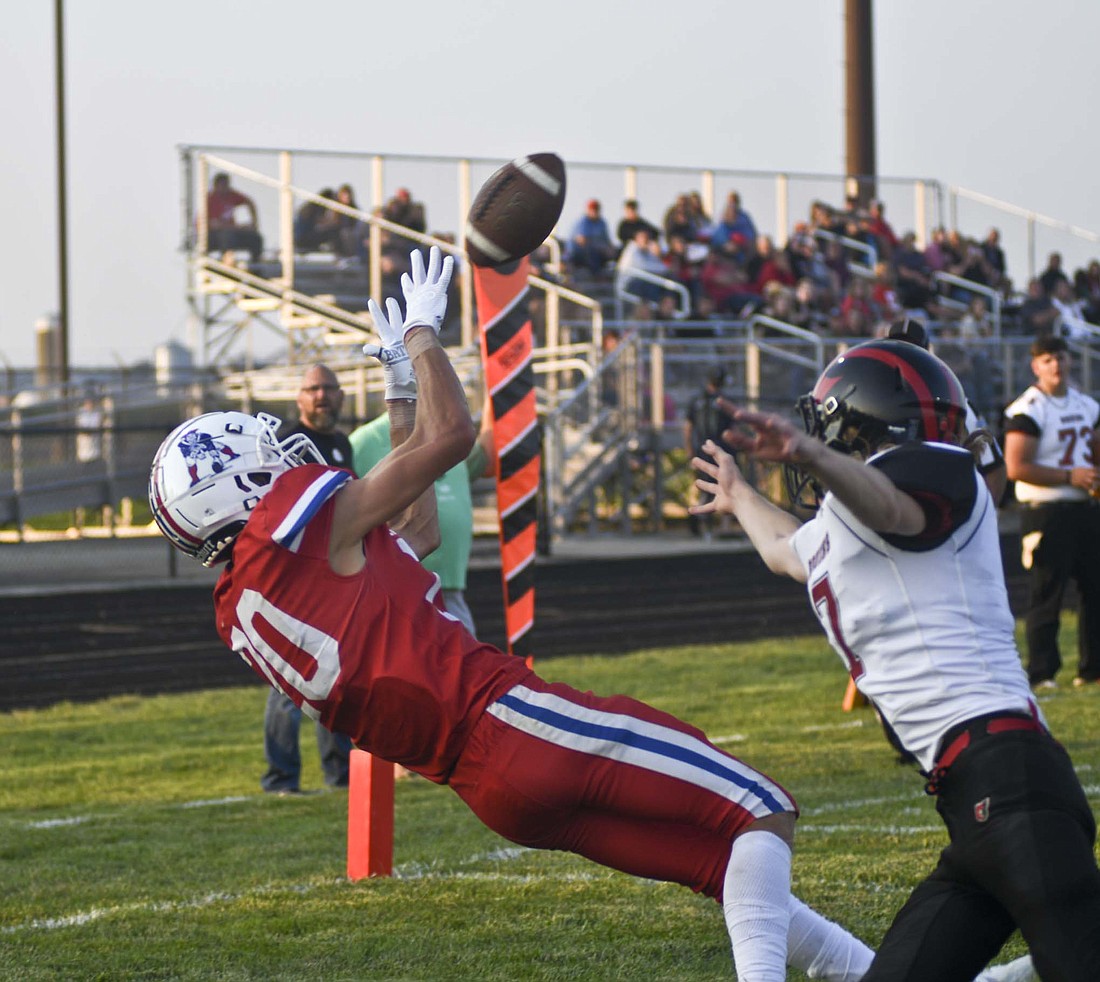 Benson Ward, a Jay County High School junior, snags a 15-yard touchdown pass from Sean Bailey in front of Blackford’s Tyler Jordan during the second quarter Friday. Ward caught three passes for 49 yards and two touchdowns as the Patriots opened 2023 with a 47-7 victory. (The Commercial Review/Ray Cooney)