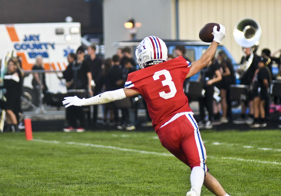 Jay County High School senior receiver Justin DeHoff raises his arms as he rushes to find a teammate to celebrate with after catching a 39-yard touchdown pass on the final play of the first half Friday. His score put the Patriots up 35-7 at halftime over the visiting Blackford Bruins on the way to a 47-7 victory. (The Commercial Review/Ray Cooney)