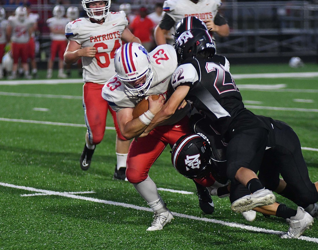 A pair of Huntington North High School football players wrap up A.J. Myers late in the fourth quarter of the Patriots' 14-9 victory on Friday. Myers rushed for 92 yards and one touchdown in the victory that moved Jay County to 2-0 for the first time since 2011. (The Commercial Review/Andrew Balko)