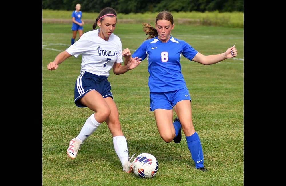 Natalie Wilson (7) and Ariel Beiswanger (8) chase after a loose ball during the Jay County High School girls soccer match on Saturday. Woodlan scored a goal in the first five minutes and went on to win 2-1. (The Commercial Review/Andrew Balko)