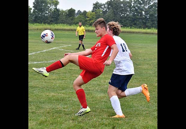 Jay County's Levi Muhlenkamp (left) kicks up at the ball while Tanner Martin of Woodlan tries to gain position during Saturday’s 4-1 victory over the Warriors. Muhlenkamp scored two of the Patriots’ four goals in the match. Muhlenkamp followed up the performance with two more goals in a 3-2 loss to Heritage on Monday.  Both of the goals came in the second half, after three unanswered in the first. (The Commercial Review.Andrew Balko)