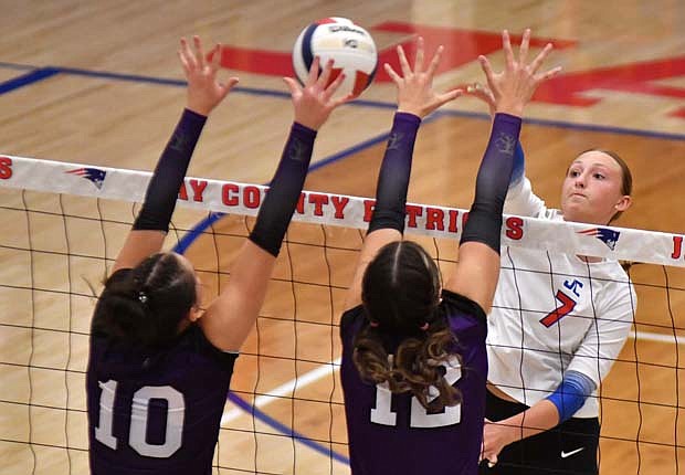 Jay County High School’s Bella Denton swings at a ball while Teigan Fortkamp and Paige Guggenbiller of Fort Recovery try to block it during their match on Tuesday. Denton led the Patriots with nine kills in the 25-22, 26-24, 25-21 loss to the Indians. (The Commercial Review/Andrew Balko)