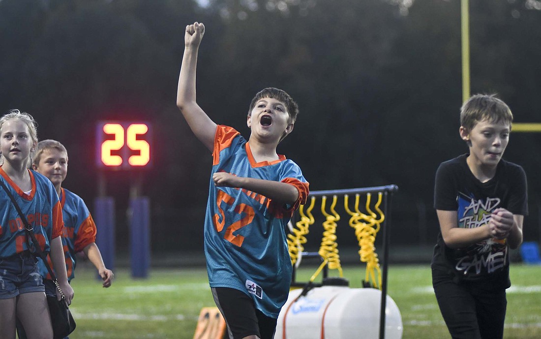 Carter Smith of the Dolphins pumps up the crowd while the Jay County Pee Wee football players were recognized at halftime of Jay County High School’s football game against Adams Central. For more on the game, see sports. (The Commercial Review/Ray Cooney)