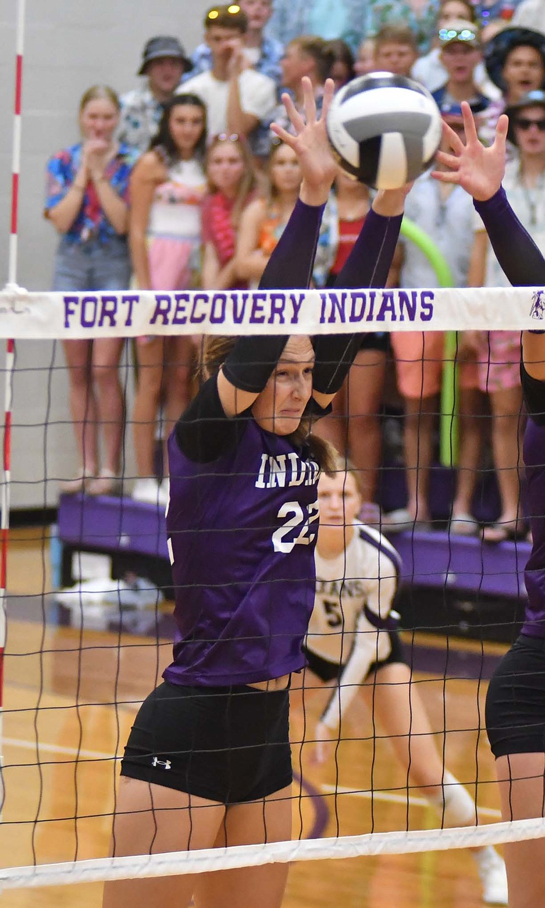 Fort Recovery High School junior Karlie Niekamp rises above the net to block a ball during the Indians’ 25-17, 25-23, 26-24 victory over Versailles on Thursday. The block was one of two for Niekamp who also had two kills. (The Commercial Review/Andrew Balko)