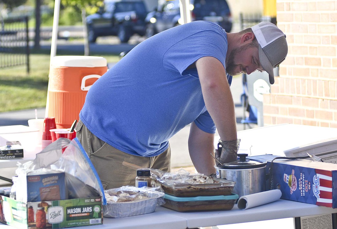 Dylan Franks, owner of The Scoop Station, works on scooping out some ice cream Sept. 1 during the fall festival in Dunkirk. The business launched in July. Its upcoming events include Thursday’s free Arts Place concert at Hudson Family Park in Portland and the Glass Days festival Sept. 30 in Dunkirk. (The Commercial Review/Ray Cooney)