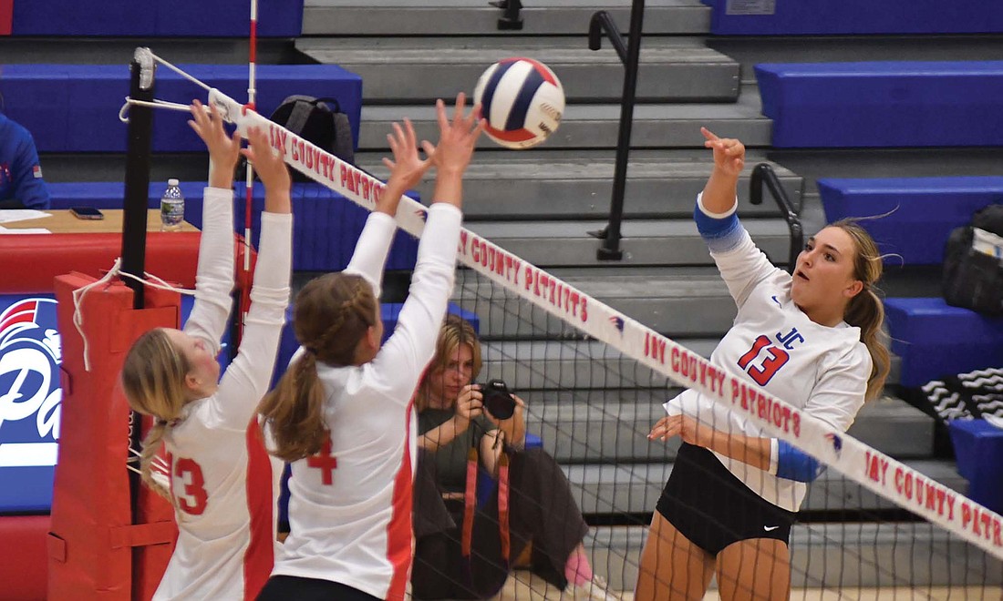 Pictured on page 10, JCHS sophomore Paisley Fugiett (13 on right) attacks a ball as Henry (13 on left) and Hillary Tobias (4) attempt to block the play. Fugiett's attack resulted in a kill off of Tobias' fingertips for the second point in Jay County's strong second set. (The Commercial Review/Andrew Balko)