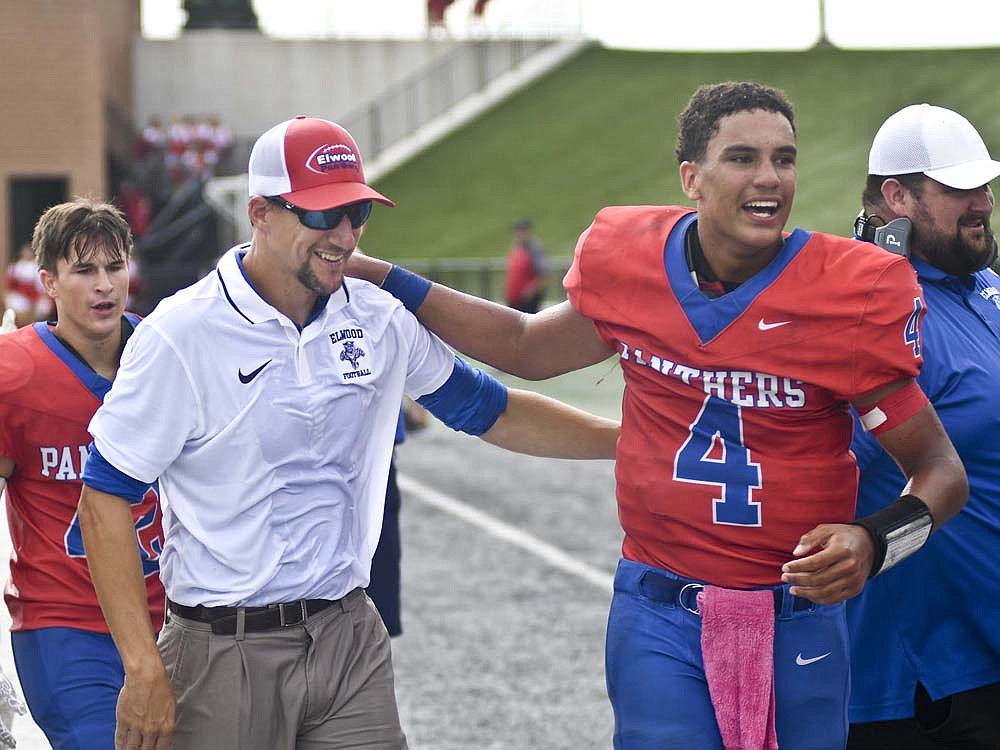 Michael Karn, a 2008 Jay County High School graduate, walks off the field alongside junior quarterback Jayden Mullins after getting doused with water following his first career coaching win Saturday. Karn's Elwood Panthers defeated the Blackford Bruins 22-12 at Indiana Wesleyan University to end a two-and-a-half-year losing streak. (The Commercial Review/Ray Cooney)