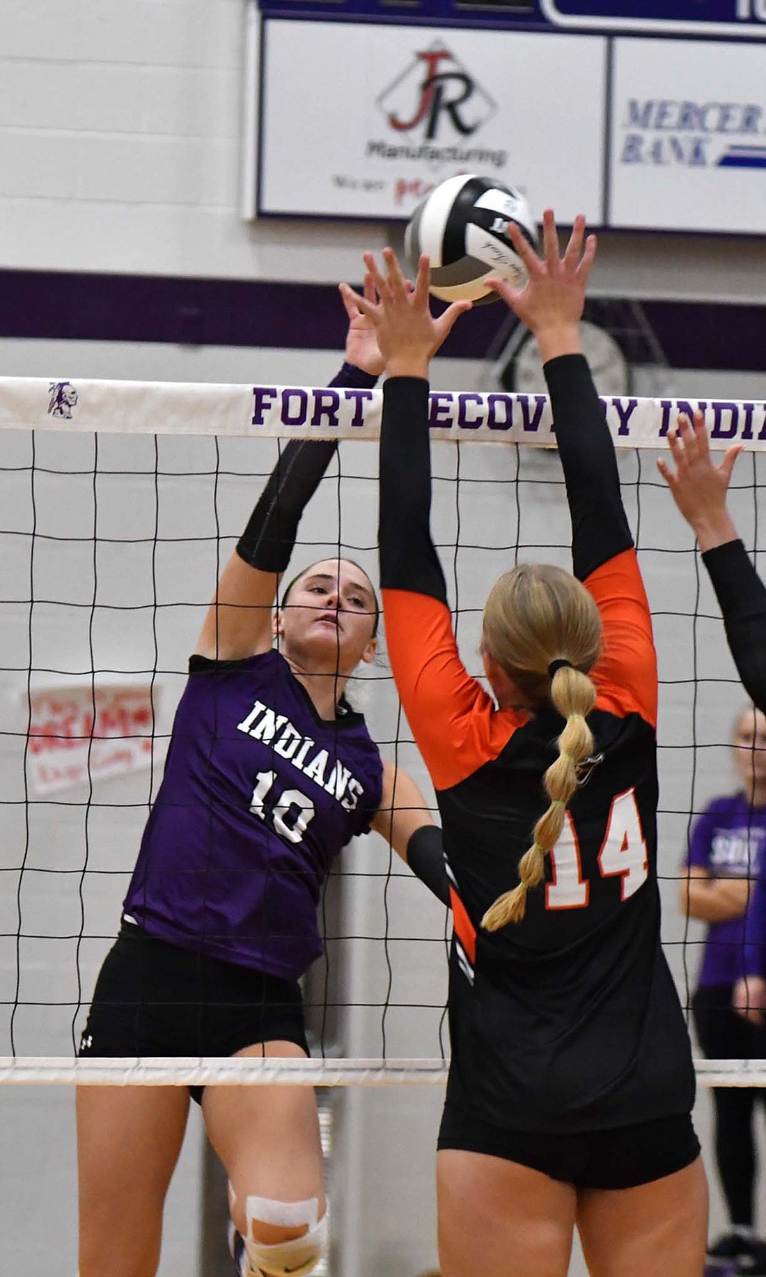 Fort Recovery High School’s Teigan Fortkamp (10) attacks a ball at the net as Madison Wendel (14) of Coldwater contests during Tuesday’s match. The Division III No. 6 Indians fell to the No. 2 Cavaliers 25-17, 25-18, 25-20. (The Commercial Review/Andrew Balko)