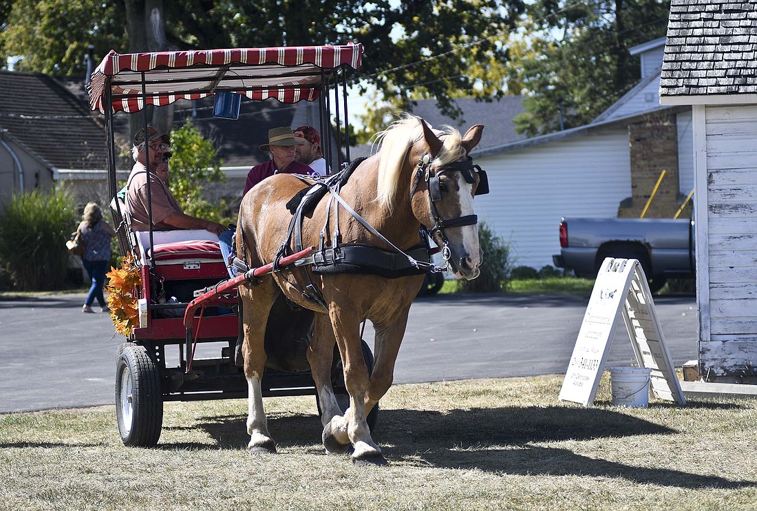 Visitors to Jay County Historical Society’s Heritage Festival start their way on a horse-drawn carriage ride Sunday on the north side of Jay County Historical Museum in Portland. (The Commercial Review/Ray Cooney)