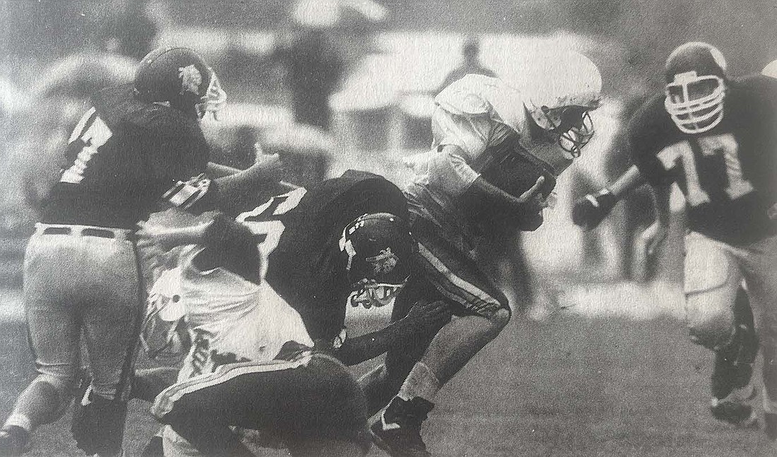 Fort Recovery High School’s Clint Bertke (60) grabs Danbury Lakeside running back Tony Puckett while the Indians’ John Tobbe (77) moves in to help during a rain-soaked game Sept. 25, 1993. (The Commercial Review)