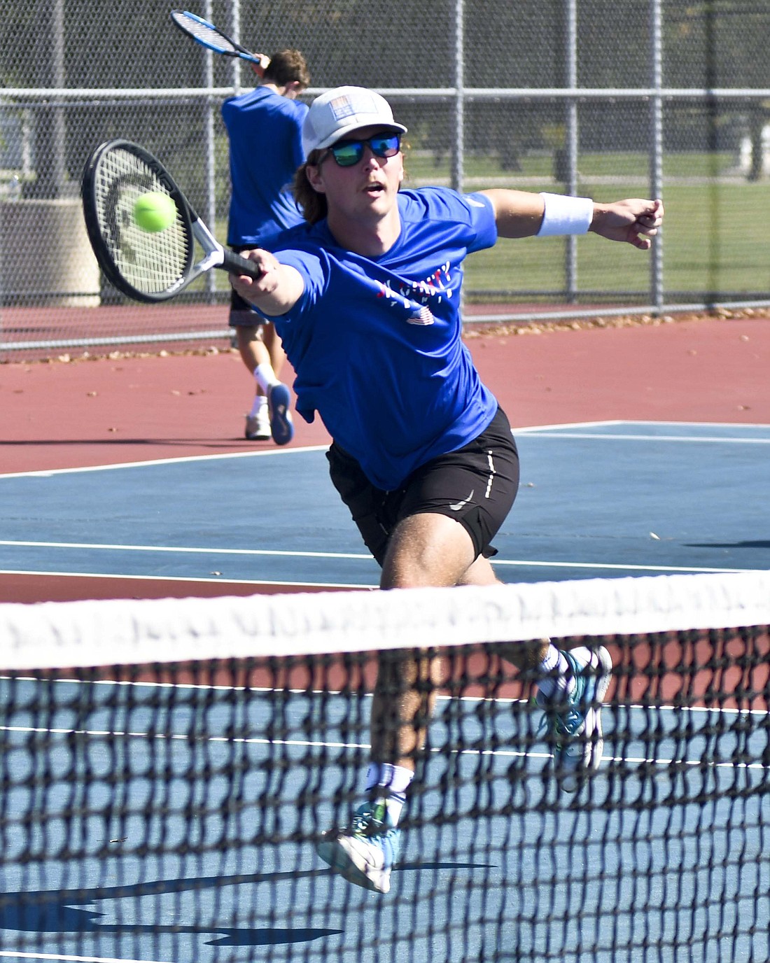 JCHS senior Sam Myers reaches over to hit a volley during the Patriots' 4-1 victory over Union City in the IHSAA Sectional 53 championship on Saturday. Myers and Gage Sims fell behind early in the No. 1 doubles match but stormed back to win 6-4, 2-6, 6-0. (The Commercial Review/Andrew Balko)