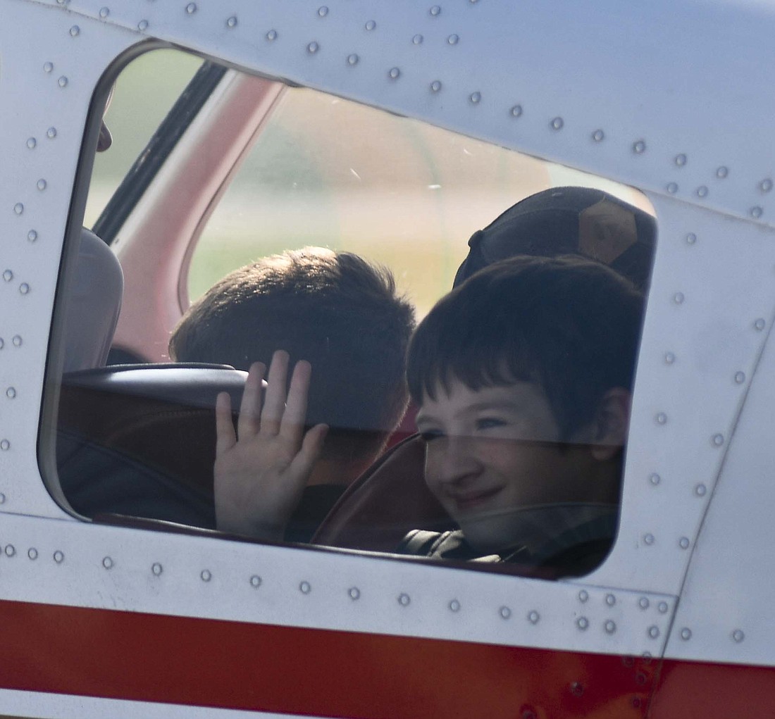 Ryan Hoblet of Convoy, Ohio, waves to his family while getting ready to take his free plane ride during Saturday’s Young Eagles event at Portland Municipal Airport. Young Eagles is an organization that offers free plane rides to children ages 8 through 17. Participants in Saturday’s event had to wait several hours for morning fog to dissipate, but were able to start flying about 11:30 a.m. (The Commercial Review/Ray Cooney)