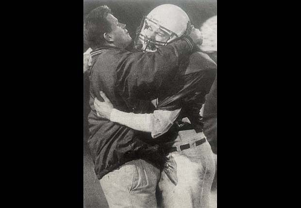 JCHS defensive coordinator Casey Thomas gives an exuberant hug to safety Jason Knapke after he intercepted a Connersville pass on Oct. 9, 1998. The Patriots earned their second win of the year by a 60-14 score behind a record-breaking performance from quarterback Brad Bennett. (The Commercial Review/Mike Snyder)