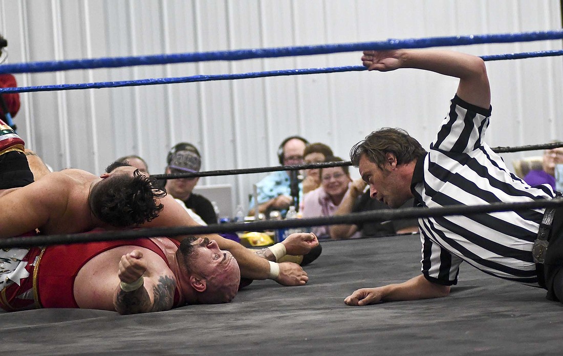 Referee Kyle Monroe of Portland counts as Blake “Money” Wright attempts to pin Michael Elgin on Saturday during Delaware County Championship Wrestling’s Cornfield Carnage event hosted by Jay County Fair Board in the Bubp Building at Jay County Fairgrounds. The event included appearances by former WWE superstars The Godfather, Victoria and Gangrel. (The Commercial Review/Ray Cooney)