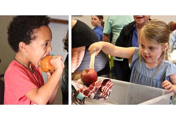 Modified bobbing for apples was one of the activities Thursday as Jay County Public Library hosted Fall Into Fun at the Library. The event also  offered an indoor maze, wagon rides, crafts, free mini pumpkins and the opportunity to  decorate the apples in caramel and other sweet treats. Pictured at right, Josie Lyons, 4, snags an apple before dressing it up in candy. At left, Nation Kiwanuka, 5, takes a bite out of his caramel apple. (The Commercial Review/Bailey Cline)