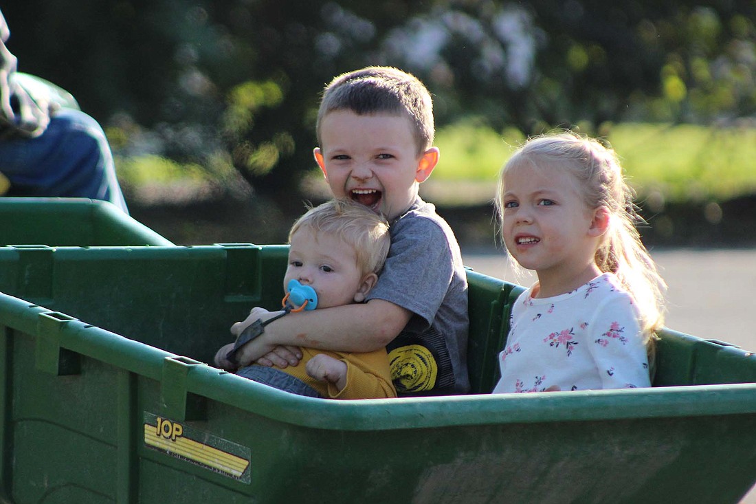 Jay County Public Library hosted “Fall Into Fun at the Library,” on Thursday. The event offered an indoor maze, wagon rides, crafts, free mini pumpkins and the opportunity to “bob” for apples and decorate them in caramel and other sweet treats. Pictured, 9-month-old Augustus Limbert, 4-year-old Haiden Young and 3-year-old Haisley Young cruise around the library parking lot in a wagon. (The Commercial Review/Bailey Cline)