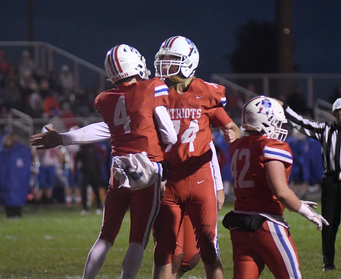 Jay County High School’s Sean Bailey (4) and Garrett Hime (74) celebrate the former’s 1-yard touchdown run during the first quarter of Friday night’s sectional football game against Kokomo. The Patriots got on the board first and still led 8-6 midway through the third quarter before falling 21-14 to the Class 4A No. 9 Wildkats. (The Commercial Review/Ray Cooney)