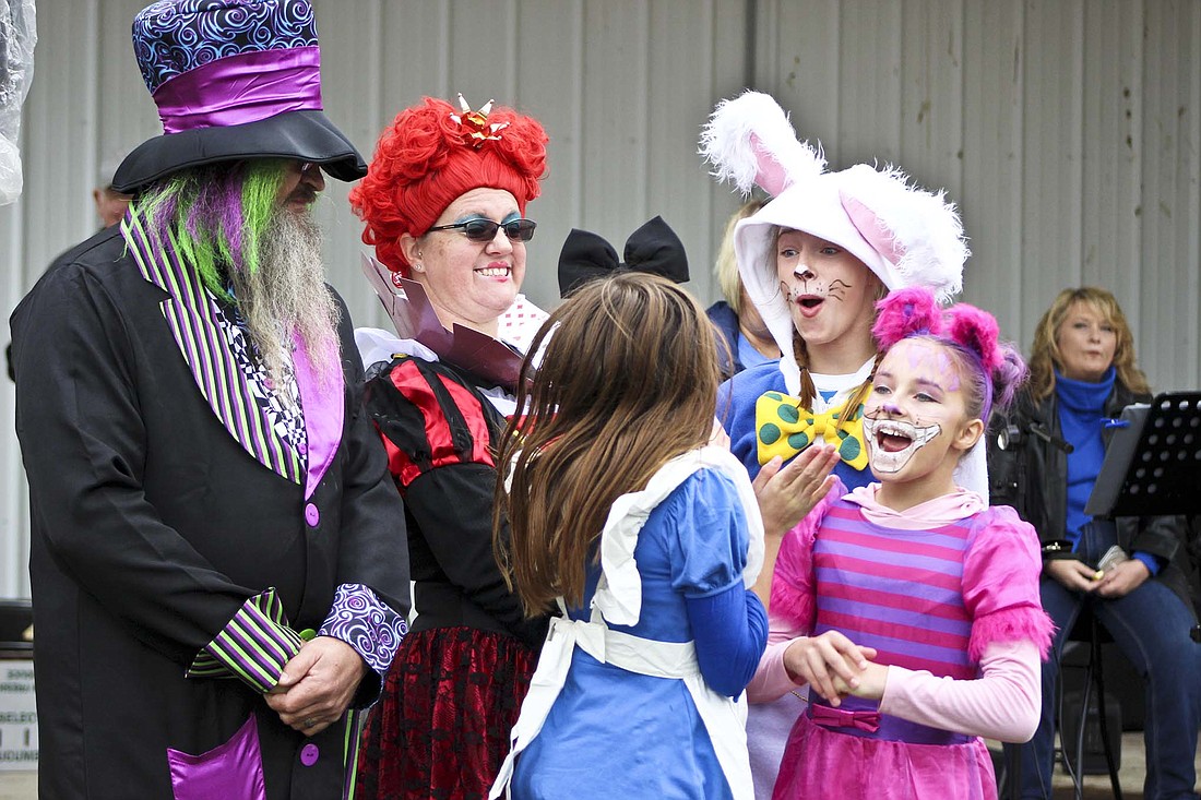 Pennville Pumpkin Festival on Saturday at Pennville Park featured a costume contest, kids games, a hog roast and a variety of other events. Pictured above, the Rowles family, dressed as characters from “Alice in Wonderland,” celebrates as they’re announced winners of the costume contest. From left are Chad Rowles as the mad hatter, Rebecca Rowles as the queen of hearts, 11-year-old Abbie Rowles as Alice, 13-year-old Gracie Rowles as the rabbit and 11-year-old Allie Rowles as the Cheshire Cat. (The Commercial Review/Bailey Cline)