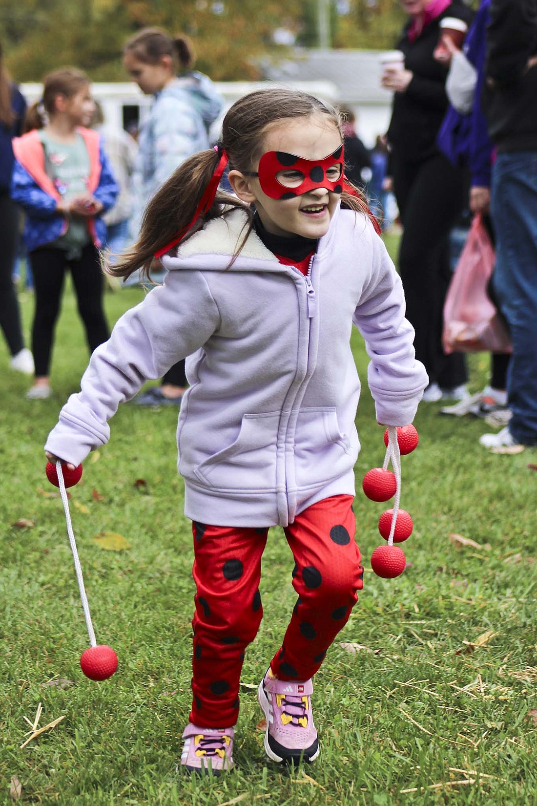 Five-year-old Bella Grayson runs toward the posts during a game Saturday as part of Pennville Pumpkin Festival at Pennville Park. She wore a costume resembling Ladybug, a super heroine from the French children’s television series “Miraculous: Tales of Ladybug and Cat Noir.” (The Commercial Review/Bailey Cline)