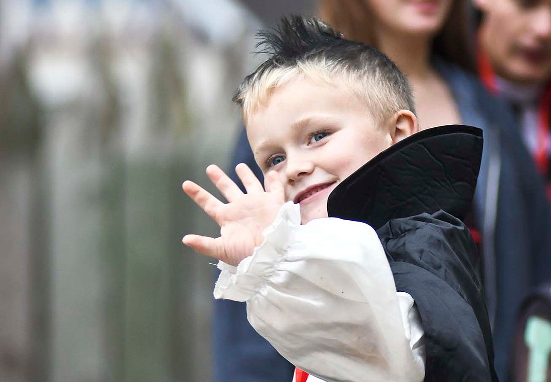 Six-year-old Oliver Otte, dressed as Dracula, waves to family while walking across the stage Sunday during the costume contest at Van Trees Park’s Hein Amphitheater in Fort Recovery. (The Commercial Review/Ray Cooney)