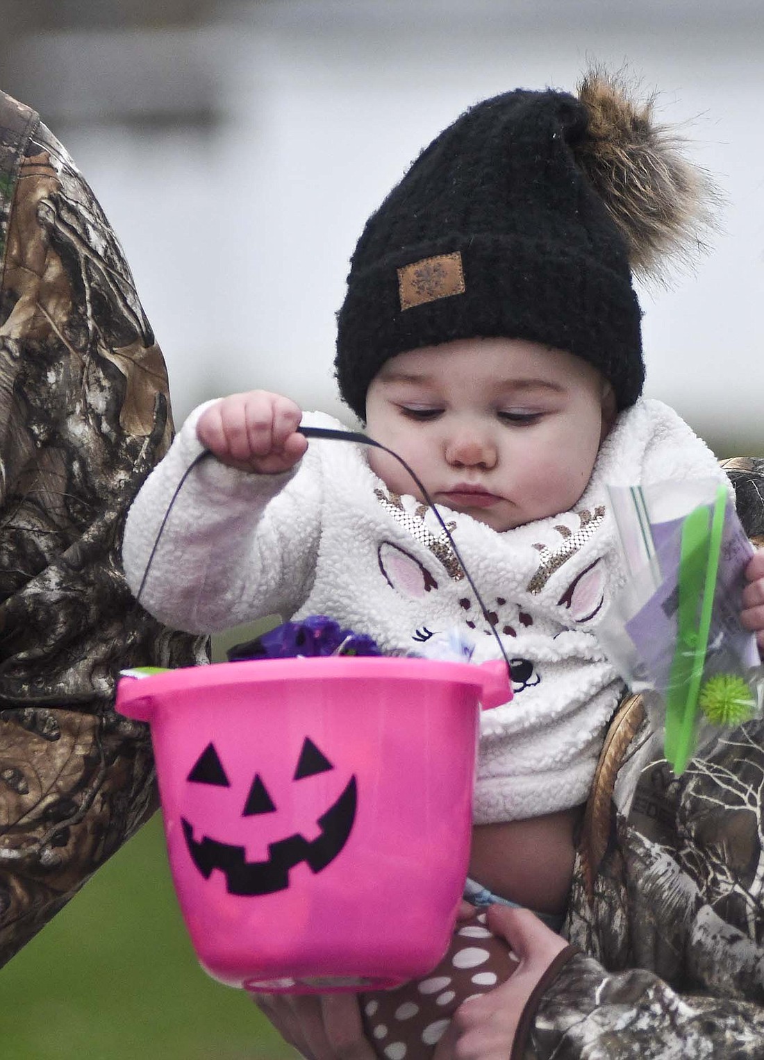 Thirteen-month-old River Bennett of Dunkirk checks out her basket of candy on Oct. 28 during the Trunk or Treat event at Dunkirk City Park. (The Commercial Review/Ray Cooney)