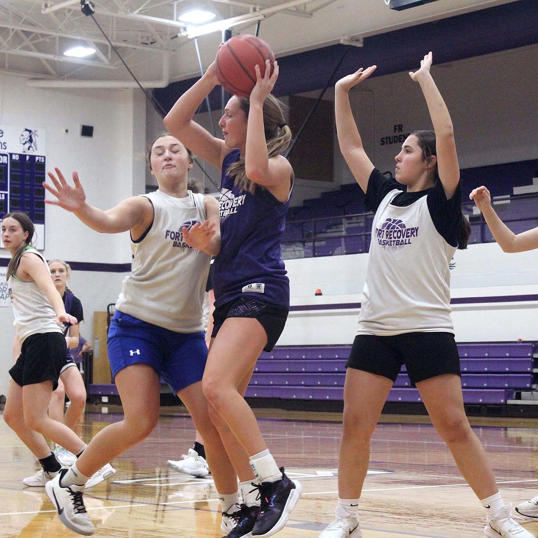 Fort Recovery High School junior Karlie Niekamp posts up two feet outside of the lane as a pair of freshmen, Sophia Guggenbiller (left) and Madie Schoenlein (right), double team her during practice on Wednesday, The Indians will host Russia for a scrimmage on Saturday before their season kicks off on Nov. 24. (The Commercial Review/Andrew Balko)