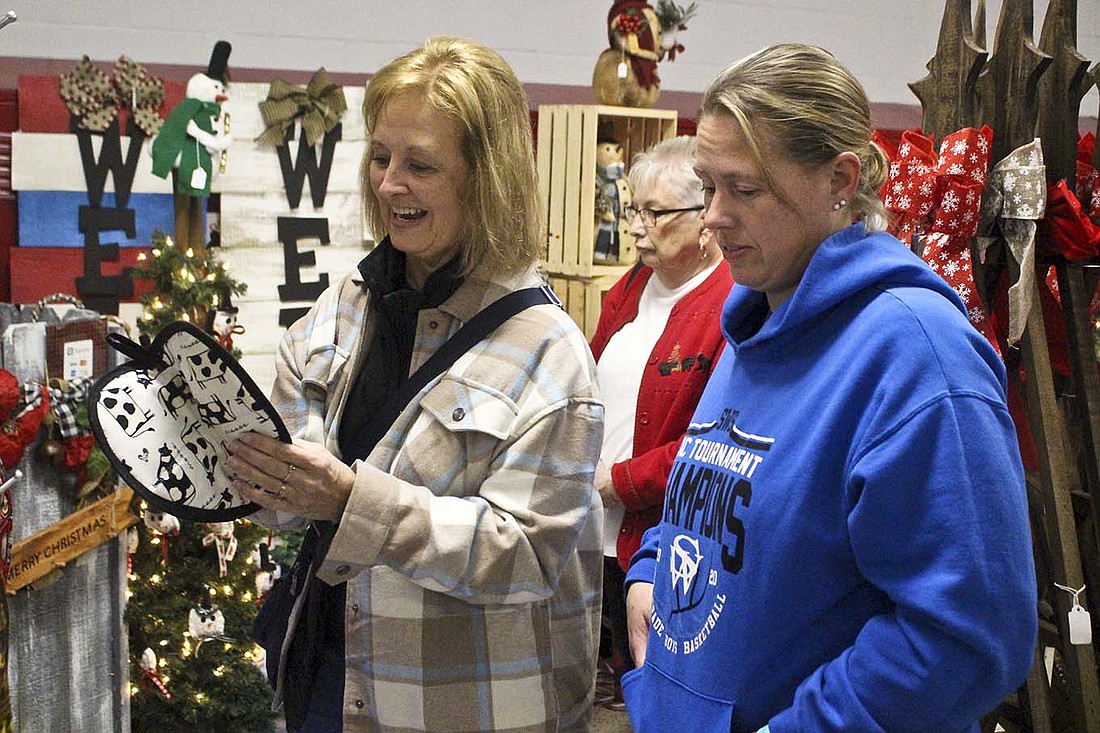 Kathy King and Chelle Gates look at potholders on sale Saturday morning at the Delts’ Holiday Crafts and Gift Show at Jay County Junior-Senior High School.(The Commercial Review/Bailey Cline)