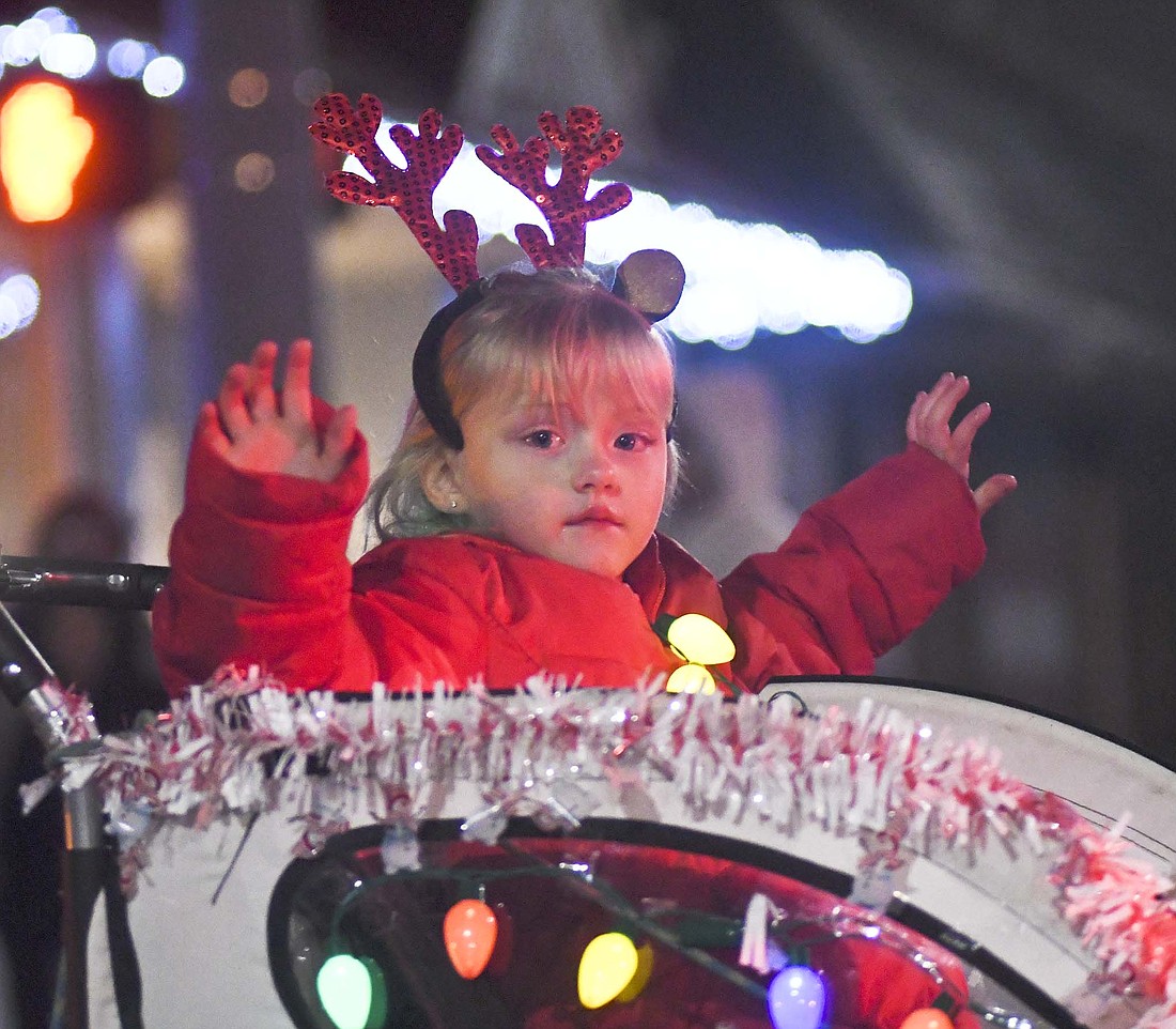 Rosalie Chambers waves while riding on a float during Saturday evening’s Parade of Lights in downtown Portland as part of Jay County Chamber of Commerce’s Winterfest activities. Winterfest continues with holiday home tours from noon to 5 p.m. Dec. 3. Tickets are available at the chamber office, 118 S. Meridian St., Portland. (The Commercial Review/Ray Cooney)