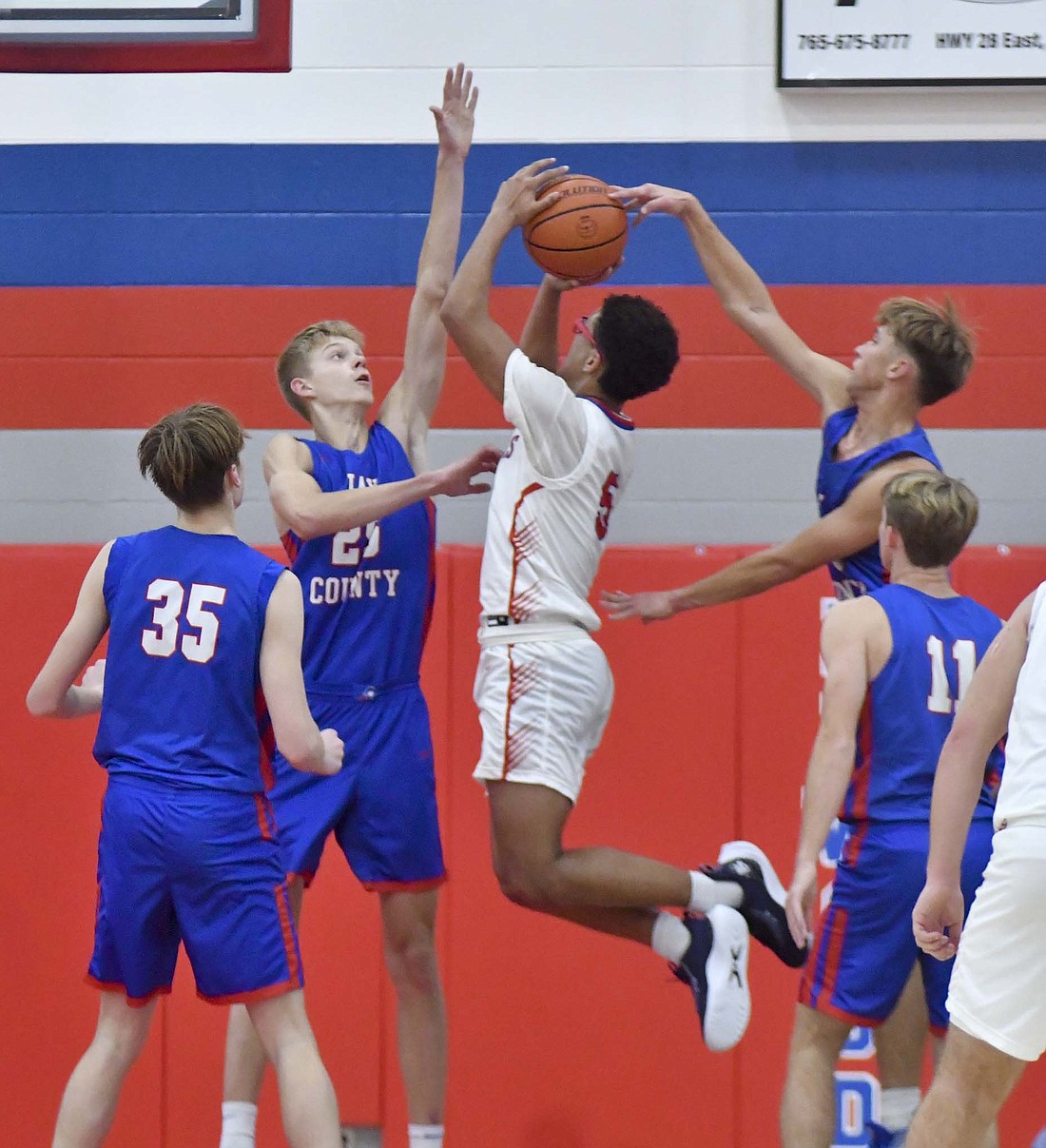 Trevor Dunnington (right) of Jay County blocks Jayden Mullins shot while Cole Forthofer contests from the front on Monday night. (The Commercial Review/Andrew Balko)