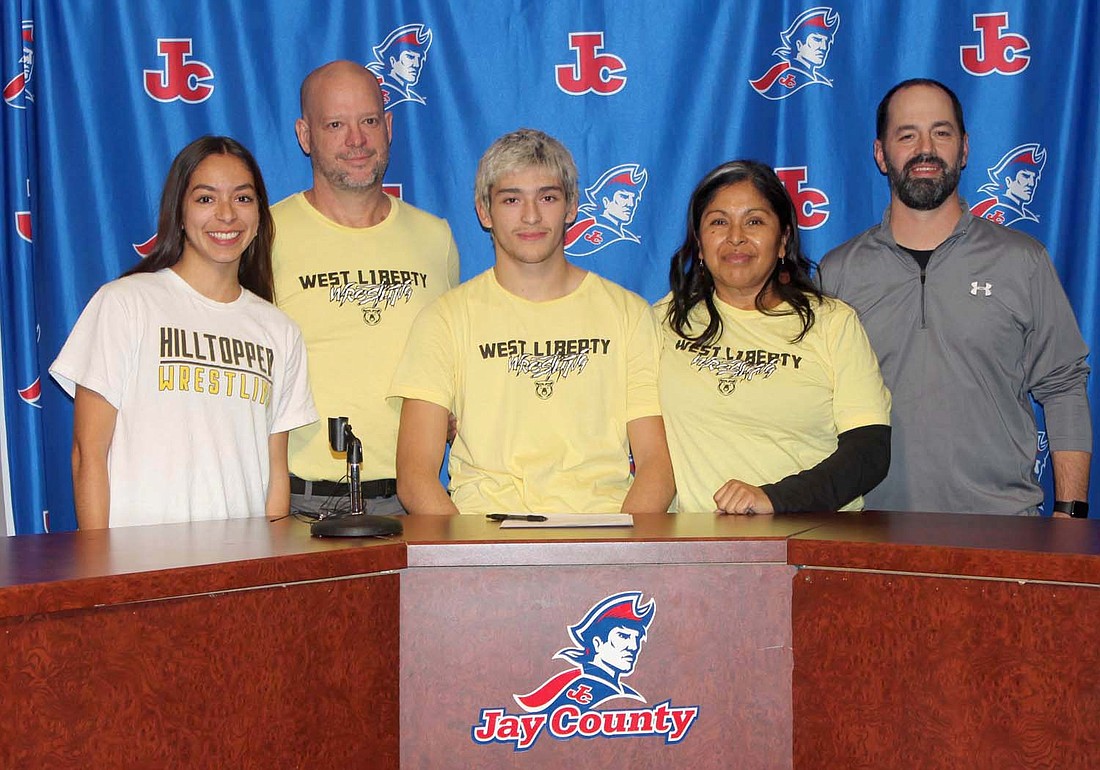 Jay County High School’s Tony Wood inked his commitment to wrestle at West Liberty University in college on Monday. Pictured from left are sister Lindy Wood, dad and assistant coach Bruce Wood, Tony Wood, mom Sylvia Wood and coach Eric Myers. (The Commercial Review/Andrew Balko)