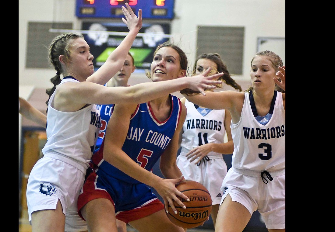 Jay County High School senior Molly Muhlenkamp works under the basket against a swarm of Woodlan defenders during the Patriots’ 60-53 victory Friday. Muhlenkamp’s defense on senior Taylor Kneubuhler of the Warriors was key in the second half. Kneubuhler had 16 points in the first 16 minutes and none after the intermission. (The Commercial Review/Ray Cooney)