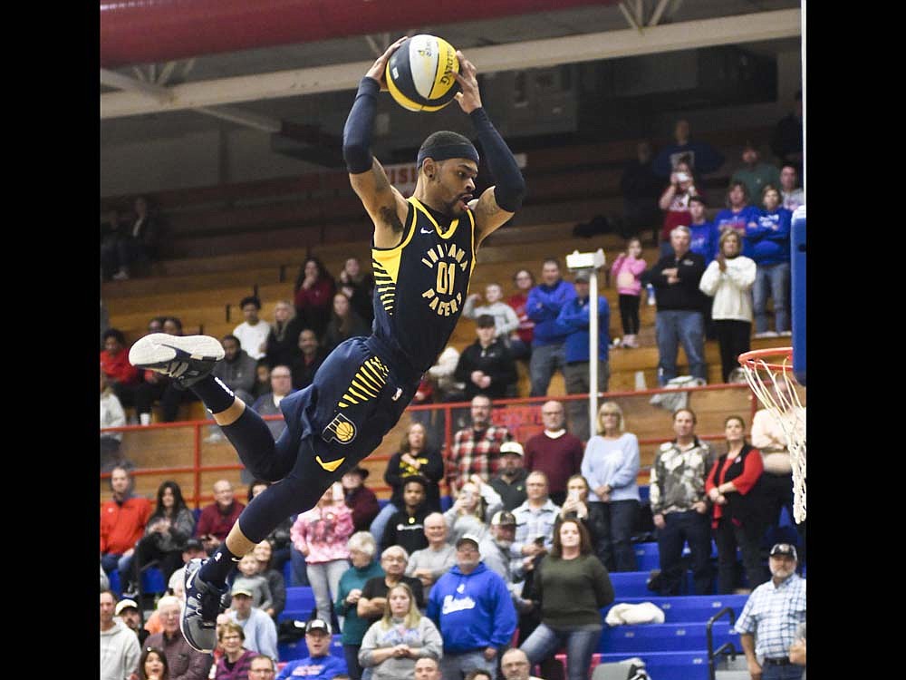 A member of the Indiana Pacers Power Pack soars toward the hoop for a dunk during the group's performance between the Jay County High School junior varsity and varsity games Saturday against Richmond. (The Commercial Review/Ray Cooney)