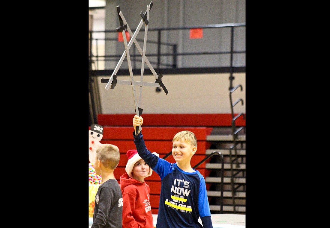 Third grader Hunter Hamilton holds up a star put together by Bloomfield Elementary students during the school’s practice session for its Christmas program Tuesday morning at East Jay Elementary. (The Commercial Review/Bailey Cline)