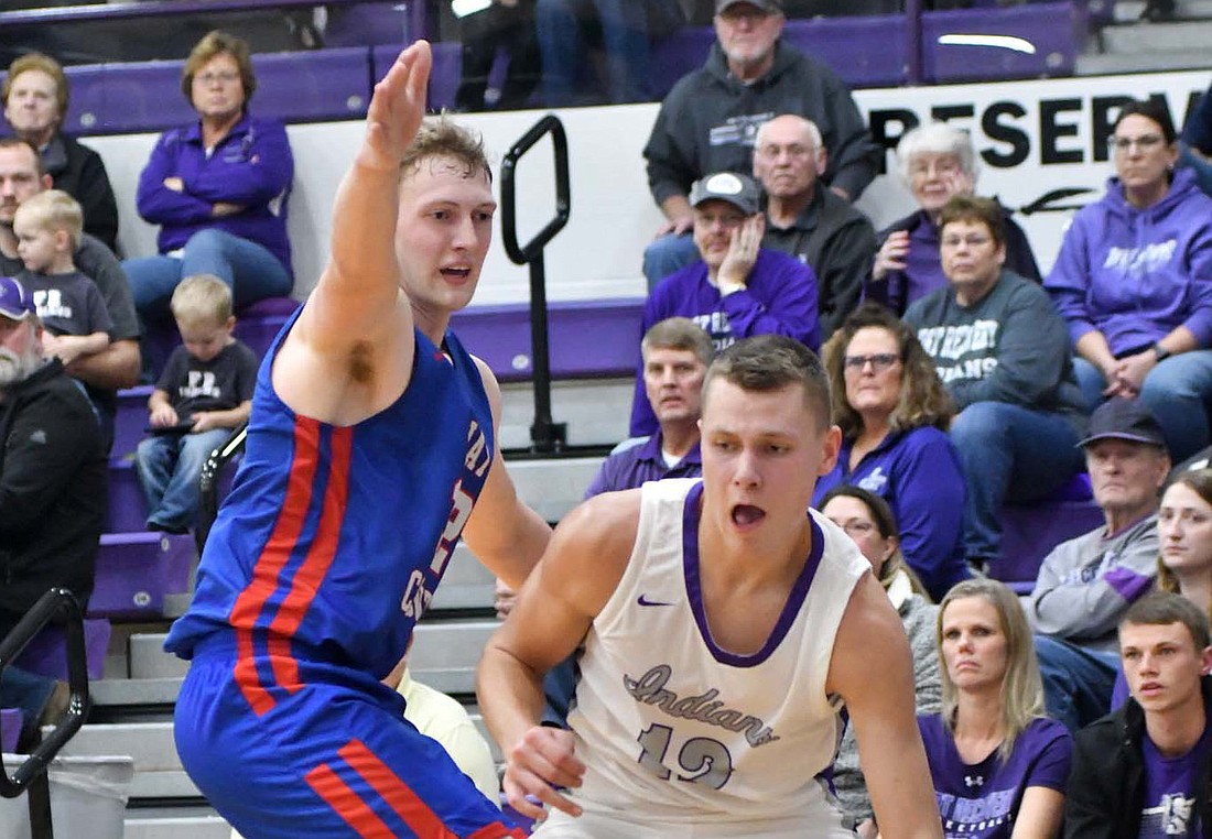 Rex Leverette of Fort Recovery High School drives the baseline past Jay County’s Westly Bihn on Saturday. Leverette snagged 11 rebounds as they held on to beat Jay County 38-31. (The Commercial Review/Andrew Balko)