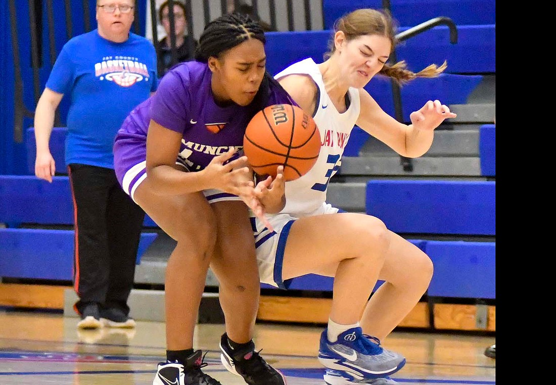 Jay County High School's Breanna Dirksen swipes away the ball from Muncie Central's Taj Isom during the 54-13 win by Jay County. The Patriots forced 40 turnovers in the contest. (The Commercial Review/Andrew Balko)