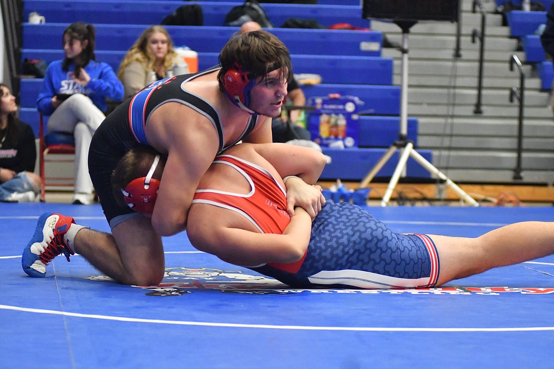 Bryce Wenk of the Jay County High School boys wrestling team gets an arm bar across Hunter Deconick's back before pinning him with a hammerlock in the 215-pound match on Friday night. Jay County beat Heritage 66-18 to open up the Allen County Athletic Conference Duels with wins from Wenk, Cody Rowles and Jacob Robinson. (The Commercial Review/Andrew Balko)