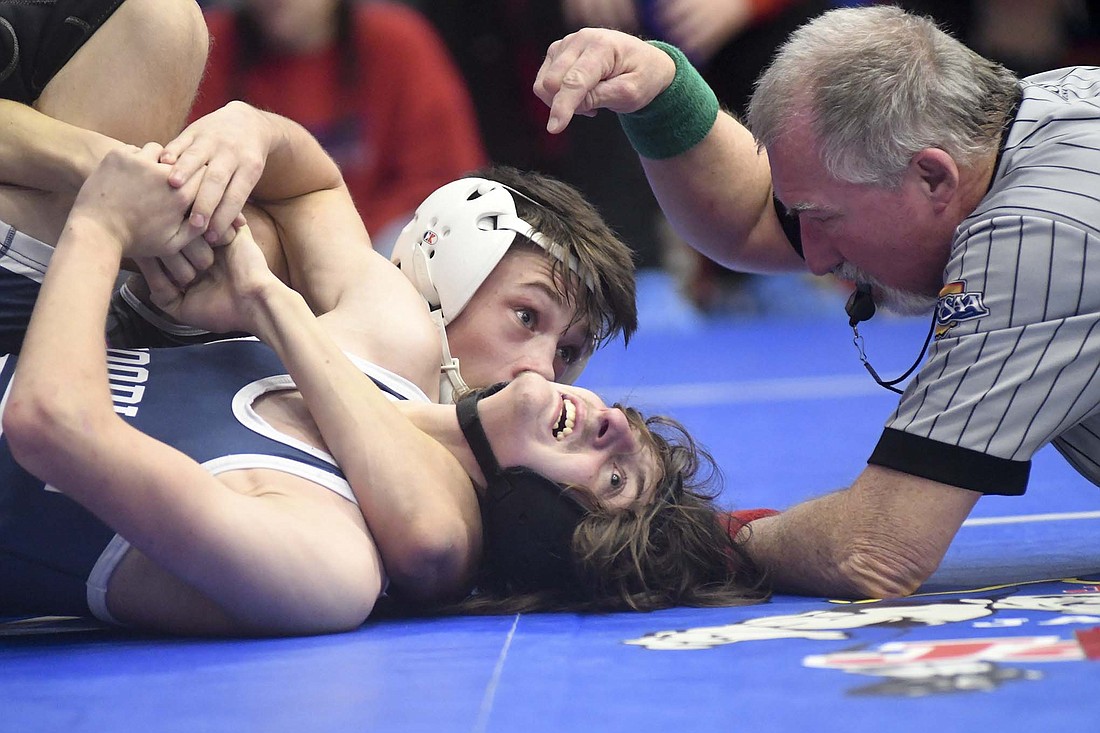 The referee points to where Woodlan’s Preston Munster isn’t quite stuck as Cooper Glassford of host Jay County tries to finish him off with a pin Saturday during the Allen County Athletic Conference Duals. Glassford went on to a 17-7 victory in the 120-pound match for the Patriots, who finished second in the seven-team field. (The Commercial Review/Ray Cooney)