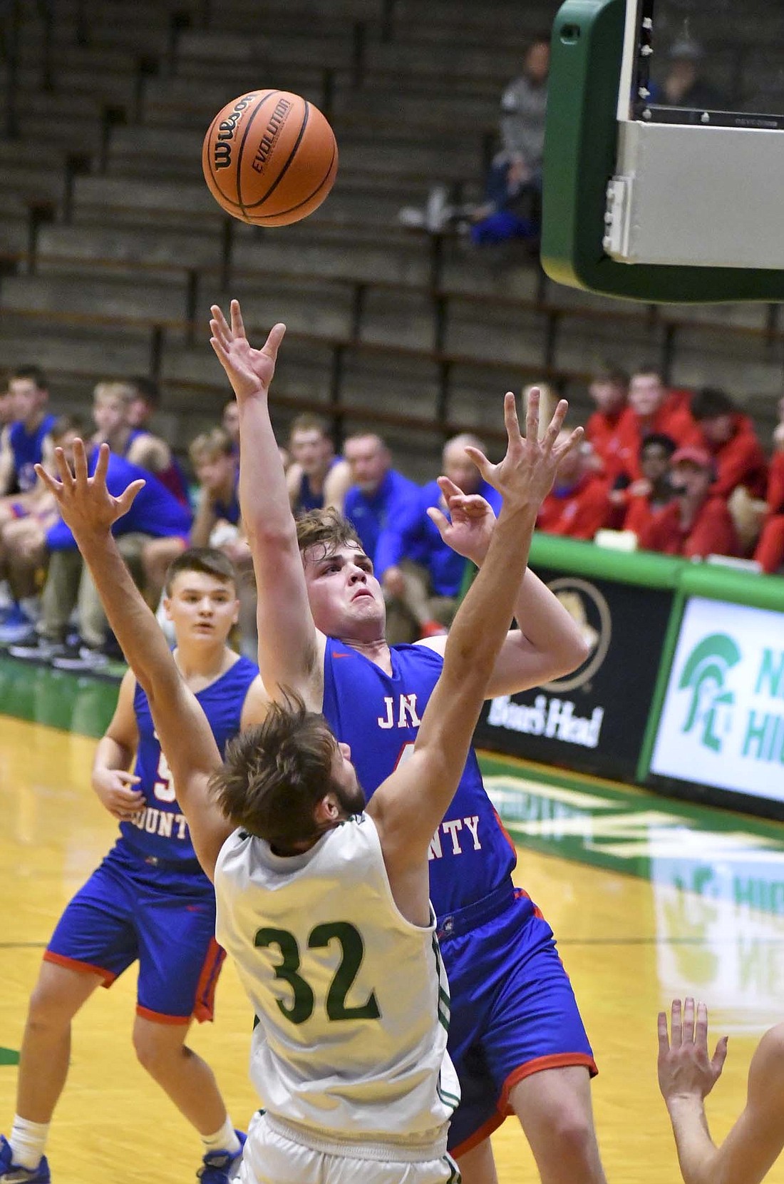 Jay County High School's Parker Nichols floats up a layup on New Castle defender Isaac Madden on Saturday evening. The Patriots struggled to defend the Trojans from three as they fell 56-44. (The Commercial Review/Andrew Balko)