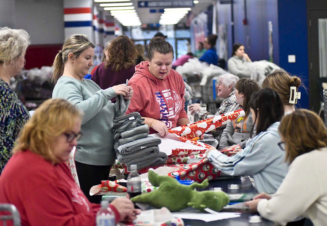 Hundreds of volunteers came out Saturday to shop at Walmart and then wrap gifts (pictured above in the commons at Jay County Junior-Senior High School) and deliver gifts to those in need as part of the eighth event day for Secret Families Christmas Charity of Jay County. (The Commercial Review/Ray Cooney)
