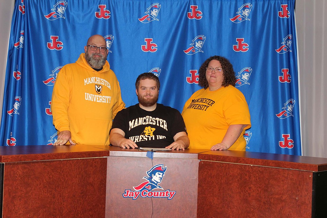 Jay County High School's Connor Specht signed to wrestle at Manchester University on Thursday. Pictured are father Hugh, Connor and mother Mandi. (The Commercial Review/Andrew Balko)