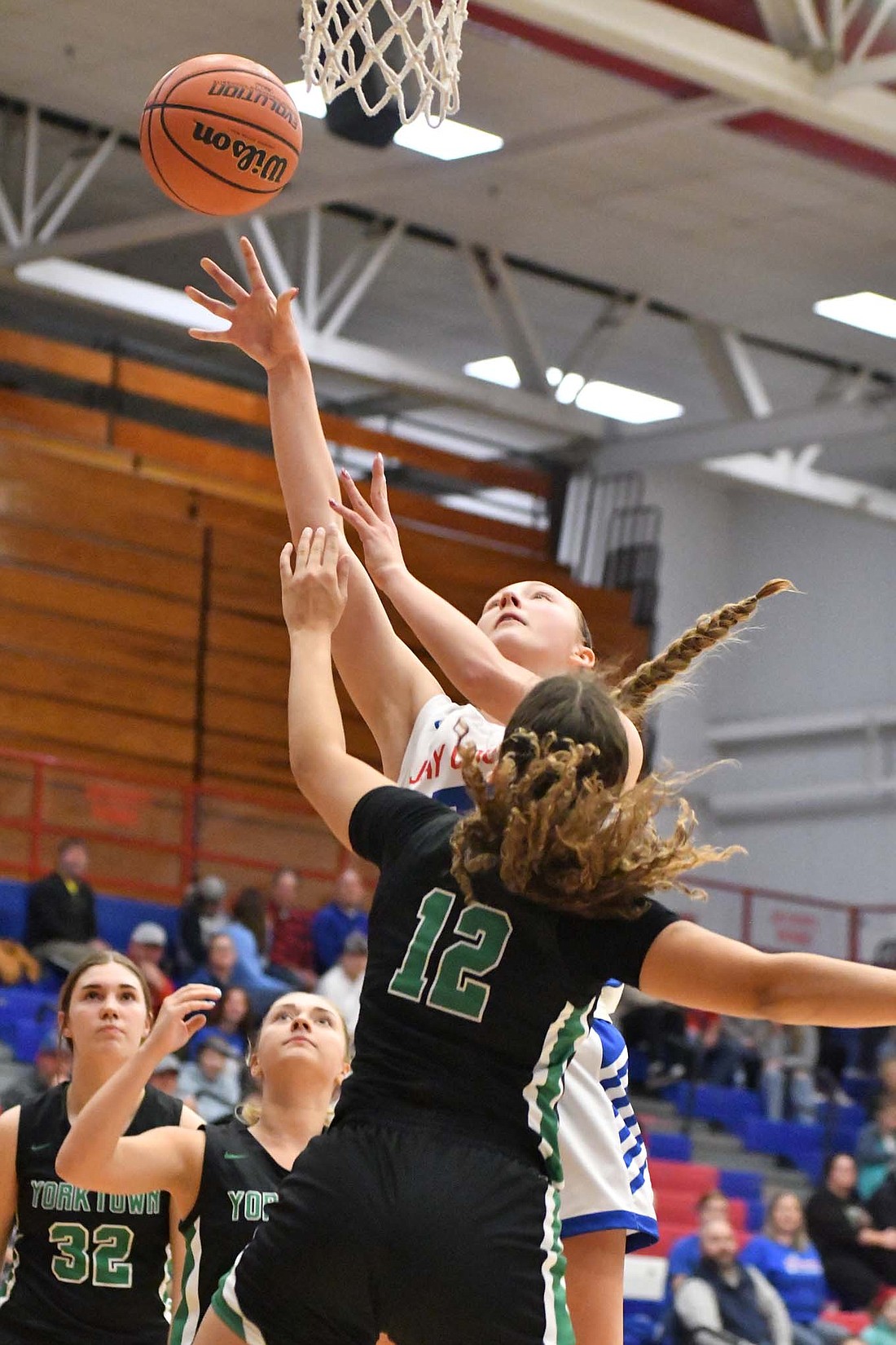 Bella Denton of Jay County High School lays up the ball over Yorktown's Oliva Conklin on Tuesday night. Denton was Jay County's second leading scorer with eight points in the 49-37 win. (The Commerical Review/Andrew Balko)